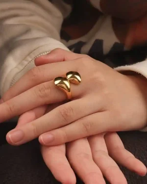 Rings design gold with various styles, including a plain band and a stone-set ring, displayed on a hand.
