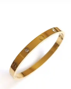 Design for gold bracelet, a stack of intricate gold-plated bracelets on a marble surface.